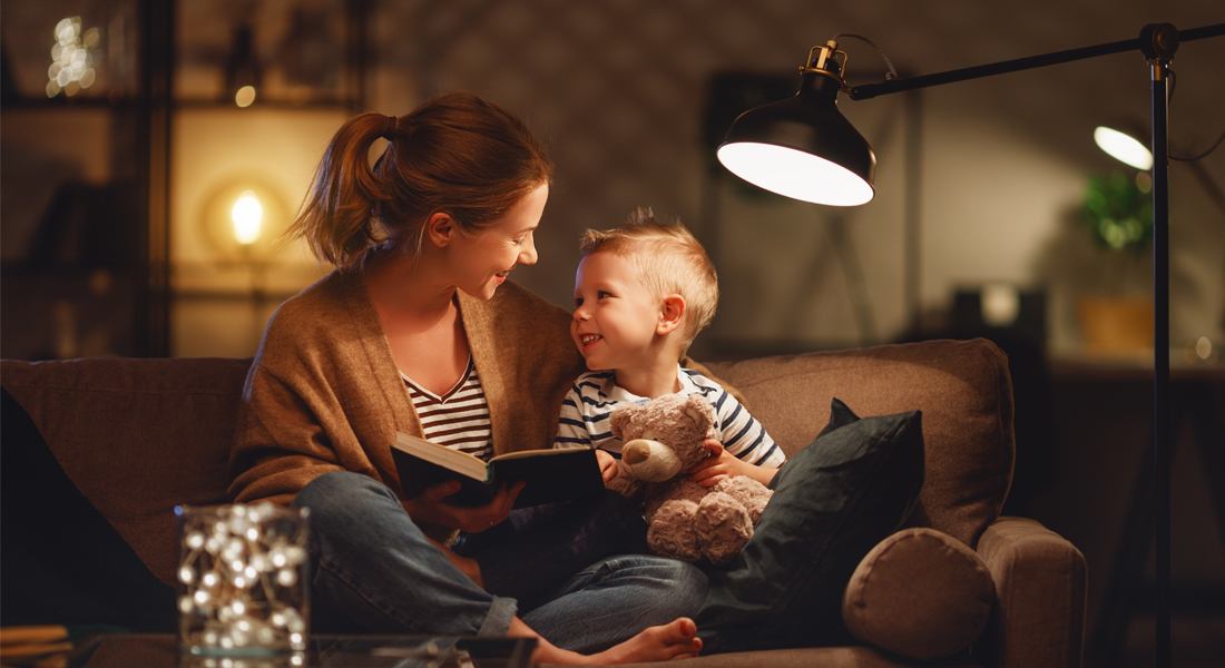 Plano de eletricidade mãe e filho no sofa a brincar com candeeiros acesos - plano de eletricidade